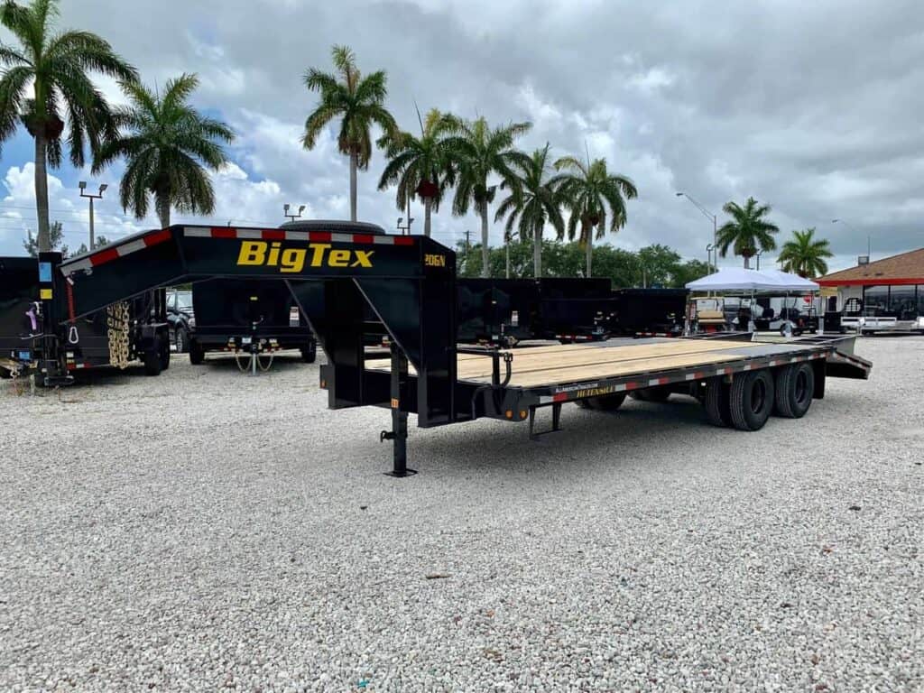 Large gooseneck trailer parked in a lot with palm trees - bumper pull to gooseneck conversion is