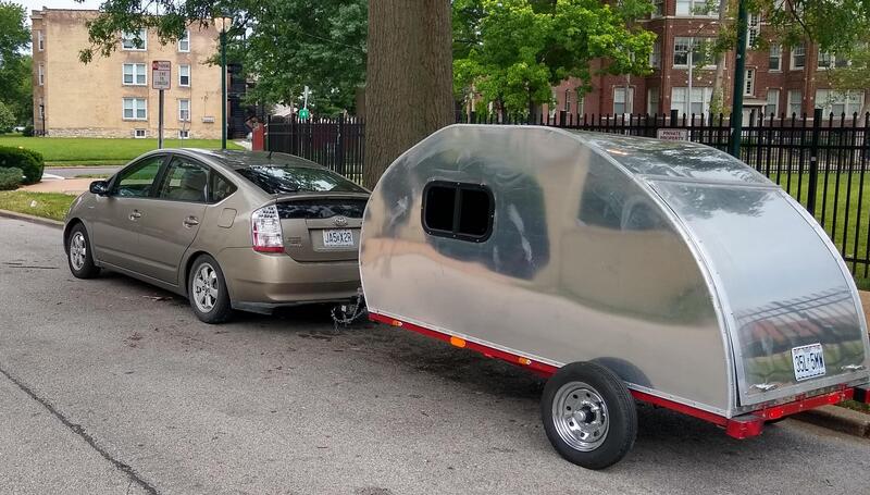 Small car towing a small teardrop trailer